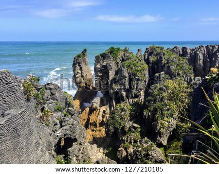 The pancake rocks and blow holes of Punakaiki on the South Island of New Zealand.  These ancient formations are the most visited natural attraction on the West Coast of the island.