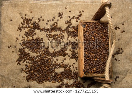 Coffee beans in wooden gasket on  burlap background