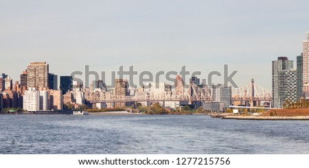 Roosevelt Island.  Roosevelt Island on the East River, New York is pictured.  Queensboro Bridge passing over the island can be seen connecting Queens and Manhattan.