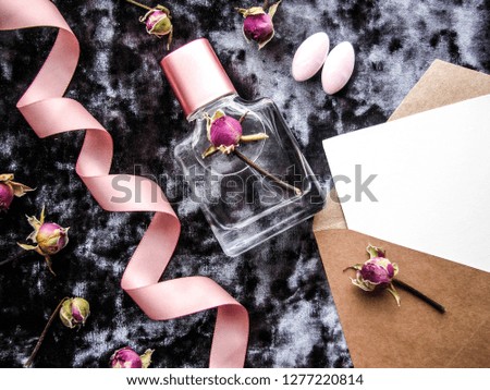 Romantic concept. perfume bottle, ribbon, flowers and envelope. congratulation. invitation.