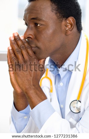 Thoughtful doctor in white coat with stethoscope in hospital