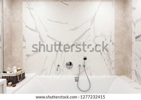 Bathroom interior. Bright bathroom with new tiles. Chrome shower, faucet, white bathroom
