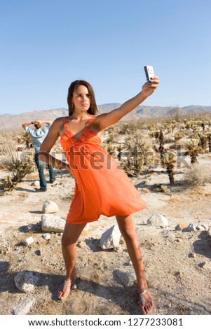 Loving young couple taking selfie in desert