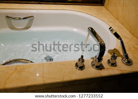 Luxury bath tub and faucet with water background photo
