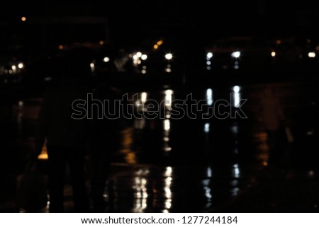 Defocused car head lamps in the rainy evening traffic jam
