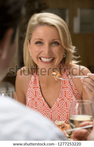 Romantic couple dining in restaurant woman eating meal view over mans shoulder