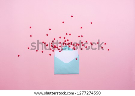 Blue letter with red spreading hearts cartoon style from paper on cardboard background. Valentine day minimal concept Flat lay Top view