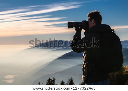 Nature photographer taking photos in the mountains - Immagine 