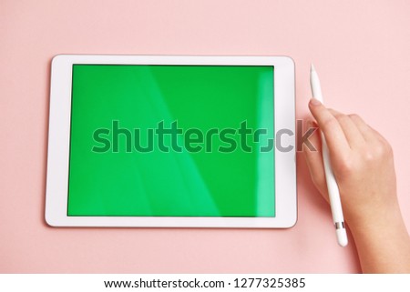 hand draws a pencil on a tablet with a chromakey on the screen
