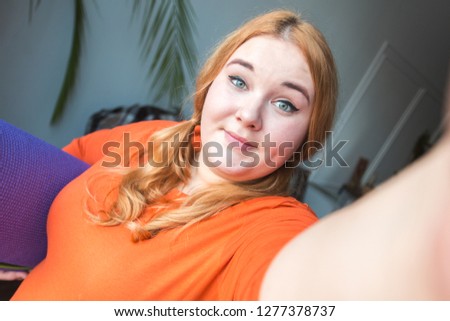 Chubby woman sport at home standing holding yoga mat taking selfie photos smiling relaxed close-up