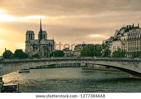View of Notre Dame cathedral in Paris, France with sunset sky as a background