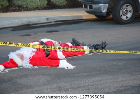 Crime Scene.  Santa Claus lays dead on the ground with a Police Chalk Line and Sheriff Do Not Cross Yellow Crime Scene Tape. Christmas Crime Scene. 