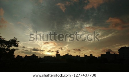 Beautiful sunset landscape with low saturation colors; some small buildings and a church 