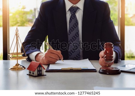 Home and land lawsuit concept, Lawyers hold a gavel to judge law and land to client.