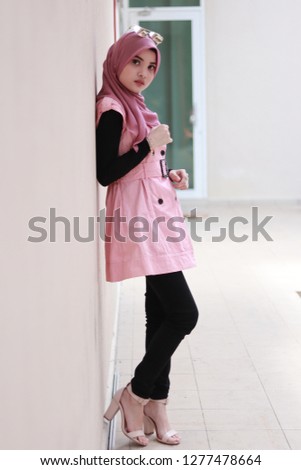 Full body portrait of cute lady wearing pink hijab and outfit. Business women modest fashion inspiration.