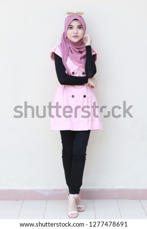 Full body portrait of cute lady wearing pink hijab and outfit. Business women modest fashion inspiration.