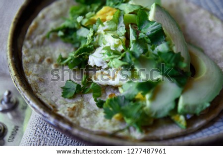 Avocado, egg, and cilantro tacos on a corn tortilla