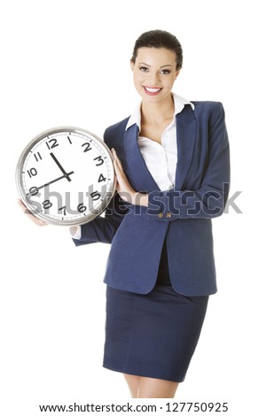 Happy young business woman holding office clock, isolated on white background