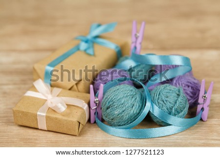 Balls of thread, clothespins and gifts on a wooden surface. Decorations for Valentine's Day and Mother's Day. Symbol of comfort
