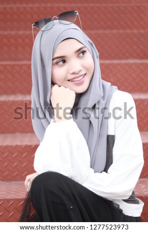 Cute hijab girl sitting on the stair. Street style fashion inspiration.