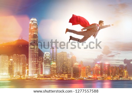 Superhero businessman flying over the city