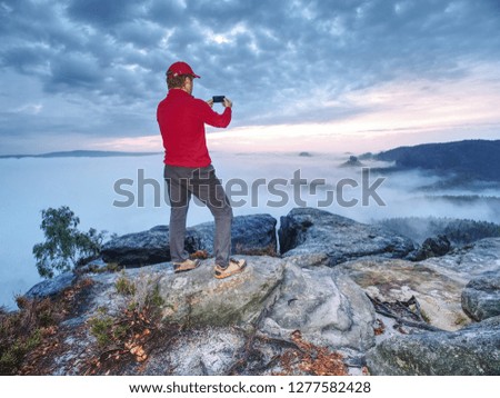 Hiker travel alone, take and share photos from outdoor trips.  Fall nature within misty morning. Photographer taking picture of tropical forest, sky and clouds