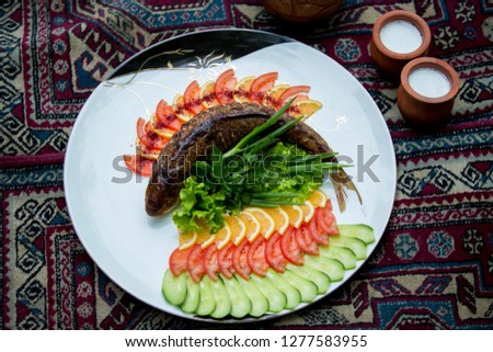 Fresh fish with herbs, spices and vegetables on a wooden background. Healthy food concept