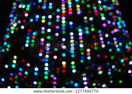 Defocused Glare from the background of the Christmas tree, against the night sky, a festive background.