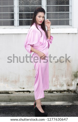 Asian women with long hair wearing short pink dress. Street style fashion inspiration. 