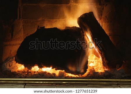 Fire burns in a fireplace by Christmas, 
big stump