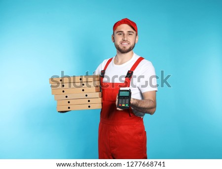Smiling courier with pizza boxes and payment terminal on color background