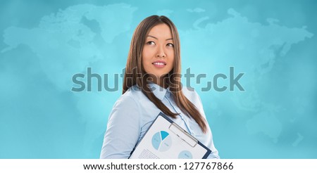 Asian business woman holding reports and smiling against world map background. Copy space