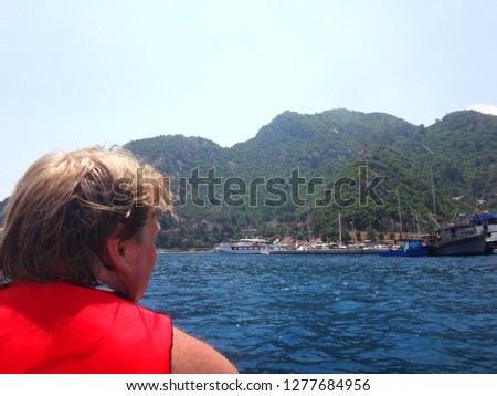 Big man on a rubber motor boat in the sea and splashing water in a sunny summer day. Taking pictures from the boat