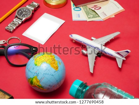 set of objects for travel isolated on red paper background.  air plane in the centre. 