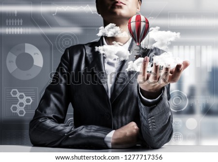 Closeup of business woman in suit presenting flying aerostate among clouds in her palm with office view on background. 3D rendering.