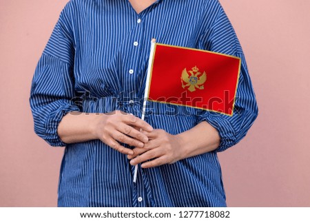 Montenegro flag. Close up picture of woman's hands holding a national flag of Montenegro.