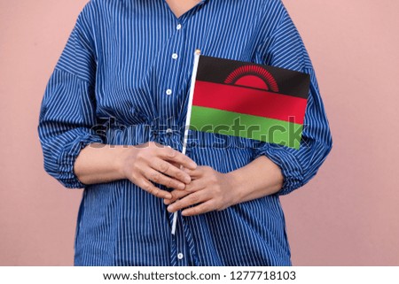 Malawi flag. Close up picture of woman's hands holding a national flag of Malawi.