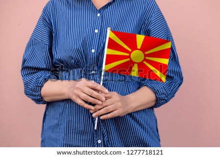 Macedonia flag. Close up picture of woman's hands holding a national flag of Macedonia.