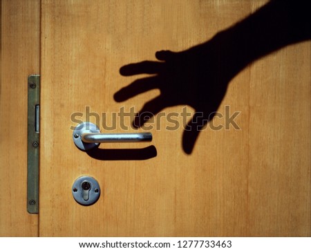 burglars shadow on a wooden door Royalty-Free Stock Photo #1277733463