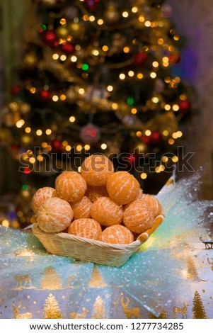 mountain tangerines on the background of the Christmas tree. Christmas photo, cleared tangerines, in the background Boke from garland
