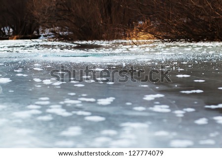 Frozen river with ice and sun reflection. Selective focus.