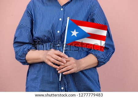 Puerto Rico flag. Close up picture of woman's hands holding a national flag of Puerto Rico.