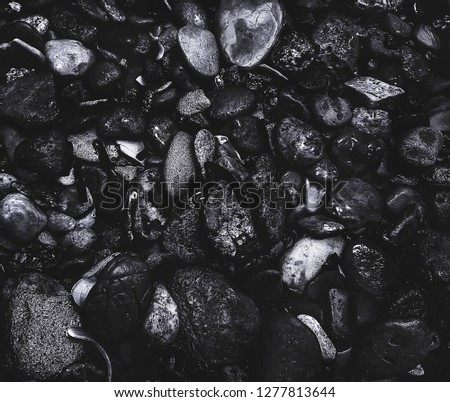 Pebbles black texture. Stone background. Rough structure mineral. Rock texture. Ocean Pictures. Gravel texture. Black background. Grunge sea bottom