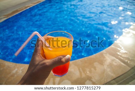 
red-yellow cocktail on vacation against the backdrop of the pool