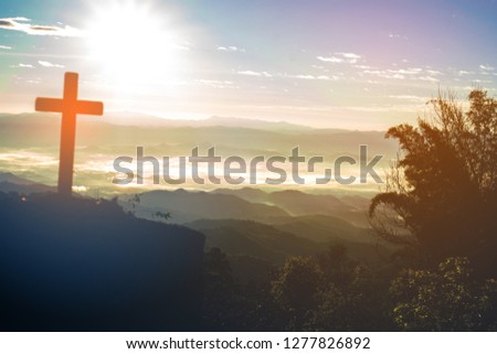 cross silhouette on the mountain at sunset.