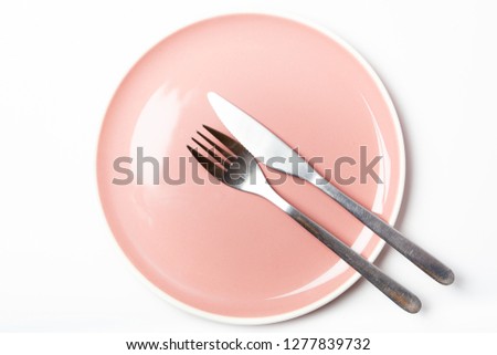 Set of empty pink plate and with cutlery in twenty past four position indicating finished meal, isolated on white background Royalty-Free Stock Photo #1277839732