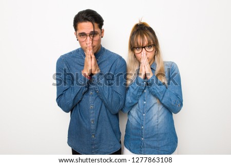 Young couple with glasses keeps palm together. Person asks for something
