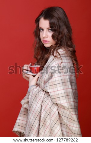 Beautiful girl drinking coffee in the morning on red background