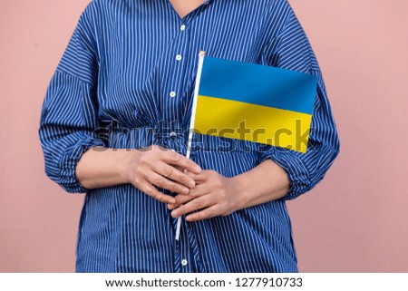 Ukraine flag. Close up of woman's hands holding  a national flag of Ukraine.