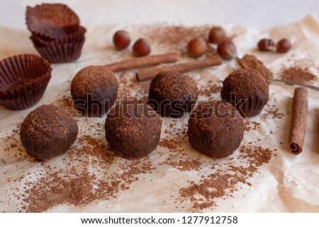 Beige brown background with a picture of a cake in the form of balls. cocoa, powdered sugar, cinnamon on waxed paper.
